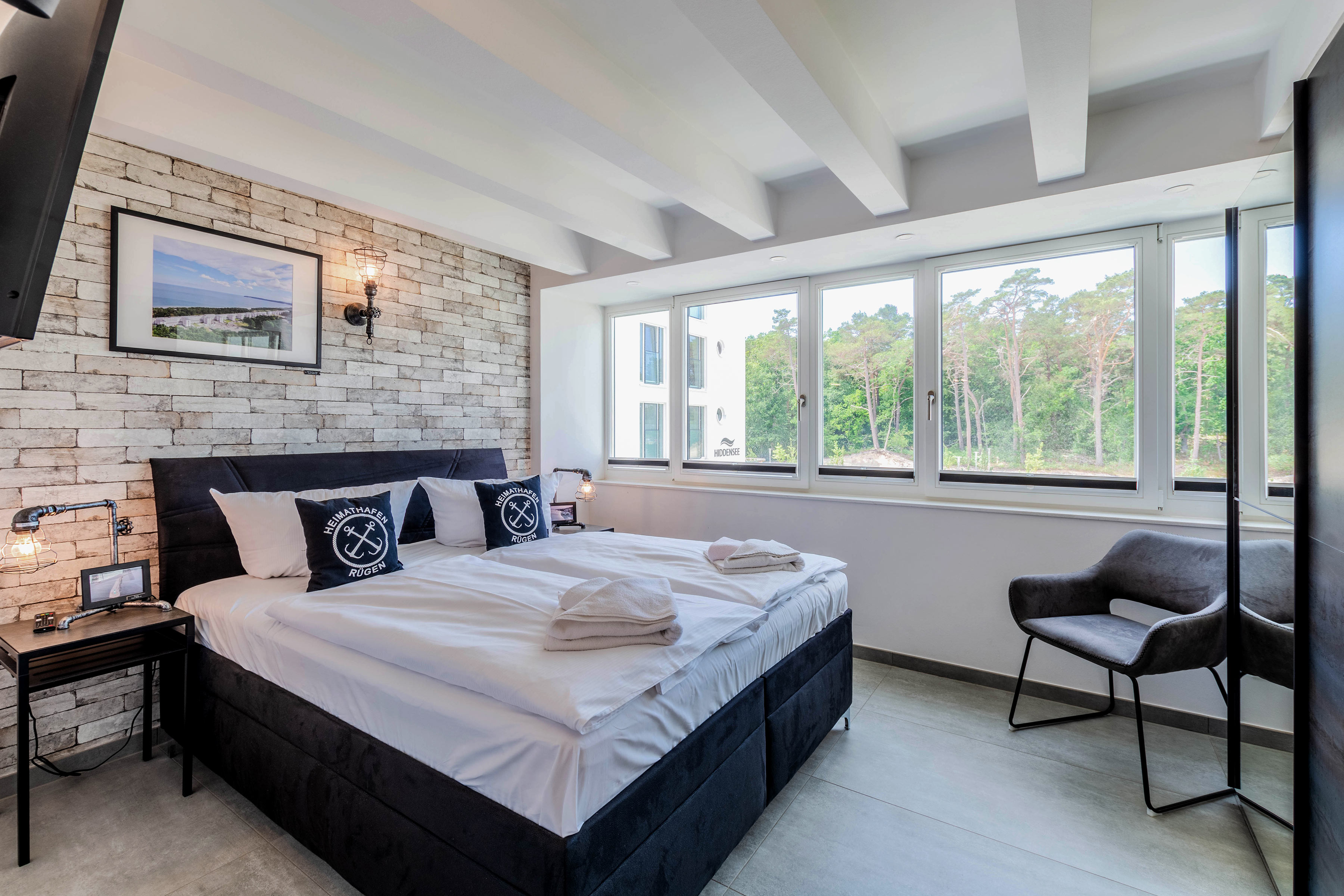 Schlafzimmer mit Steinwand und Fensterfront