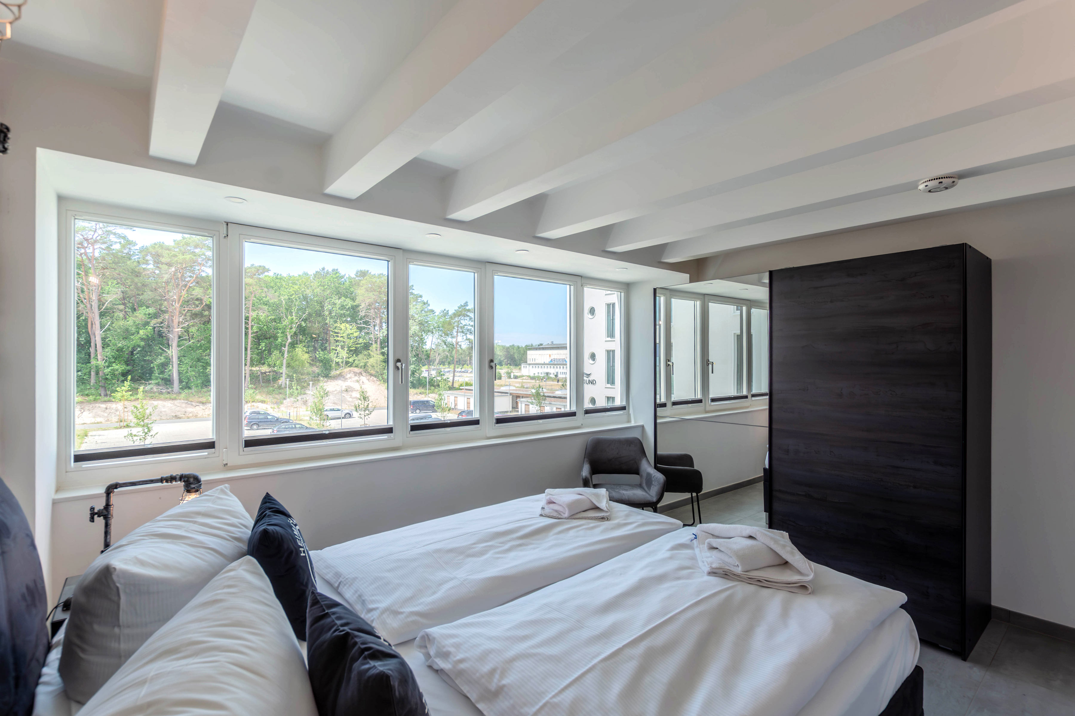 Schlafzimmer mit großer Fensterfront und Schrank