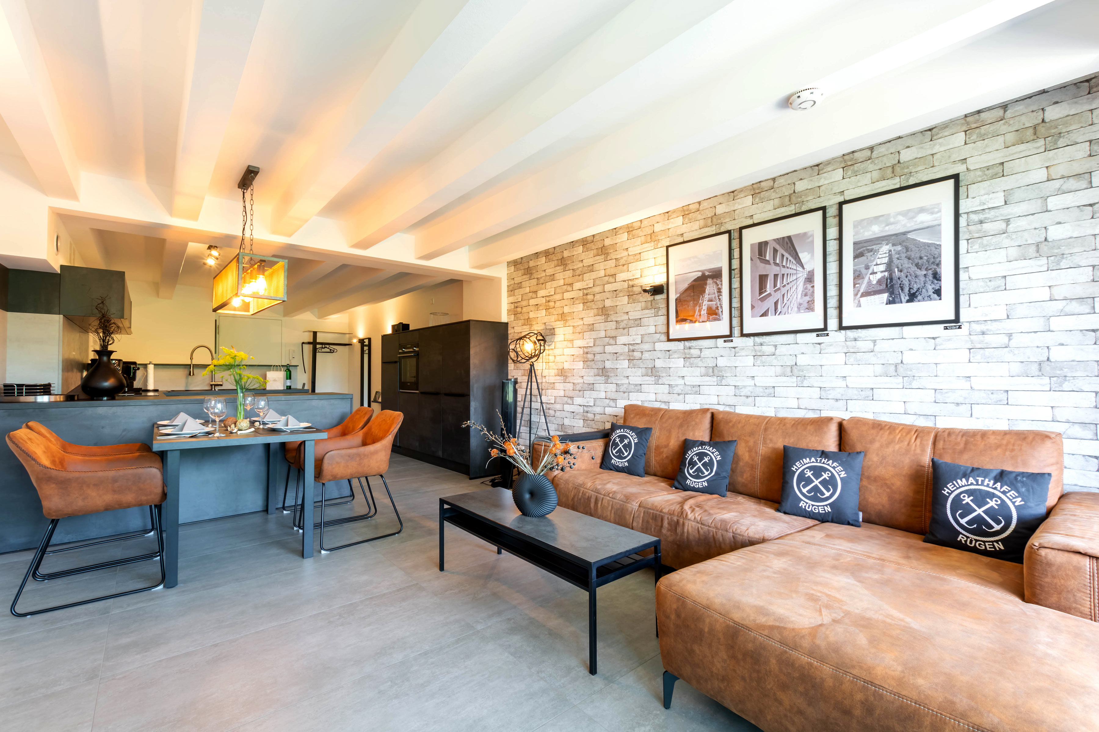 Loft Lori – 125 m² Industrie-Loft in Prora Rügen, Wohn- und Essbereich mit Steinwand